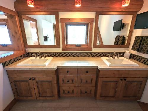 a bathroom with two sinks and two mirrors at Eagles Nest at Elk Highlands in Whitefish