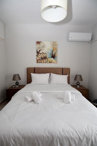 a bedroom with a large white bed with two lamps at Bella Vista in Kavála