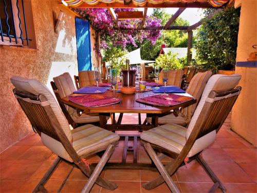 Une table et des chaises en bois sont disponibles sur la terrasse. dans l'établissement LOU PANTAI, à Villeneuve-Loubet