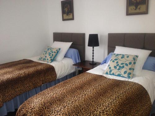 a room with two beds and a table with a lamp at Chambres et Table d'hôtes La Belle Lensoise in Lens