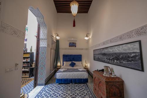- une chambre moroccane avec un lit et un miroir dans l'établissement La Cheminée Bleue Fes, à Fès