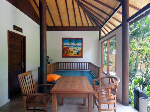 comedor con mesa de madera y sillas en Coconut Dream, en Gili Trawangan
