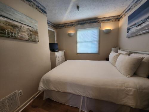 特拉弗斯城的住宿－North Shore Inn TC 300，卧室配有白色的床和窗户。