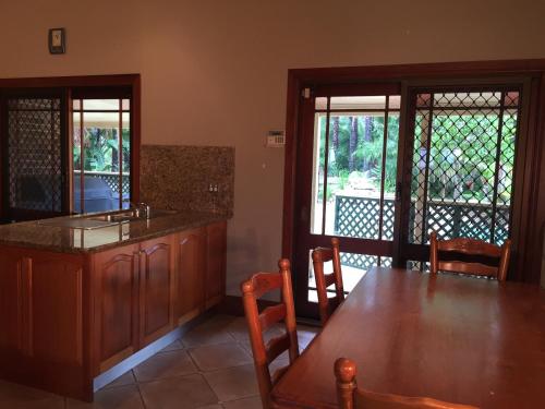 a kitchen with a wooden table and a dining room at Relaxin in Dural