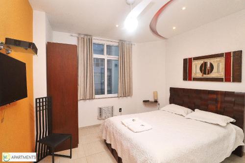 1 dormitorio con 1 cama y TV de pantalla plana en Modern 3BR with ocean view, en Río de Janeiro