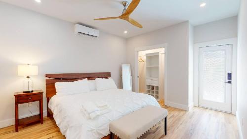 - une chambre blanche avec un lit et un ventilateur de plafond dans l'établissement Historic 2BR 1BA with King bed-Fast Wi-Fi 75 OLED TV, à Wilmington