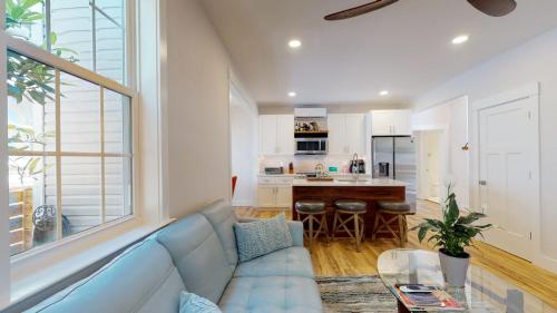 a living room with a blue couch and a kitchen at Historic 2BR 1BA with King bed-Fast Wi-Fi 75 OLED TV in Wilmington