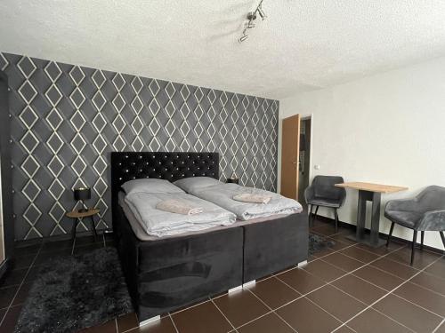 Bett in einem Zimmer mit einer Wand in der Unterkunft Ferienwohnung - Gästewohnung in Forst(Lausitz) in Forst