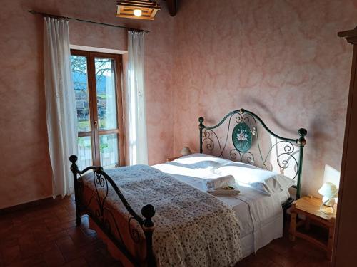 una camera da letto con un letto con lenzuola bianche e una finestra di Agriturismo Le Case di Quarantotti a Norcia