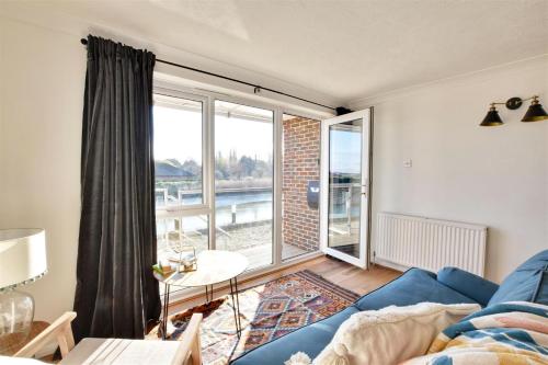 a living room with a blue couch and a large window at Nine The Boathouse in Rye