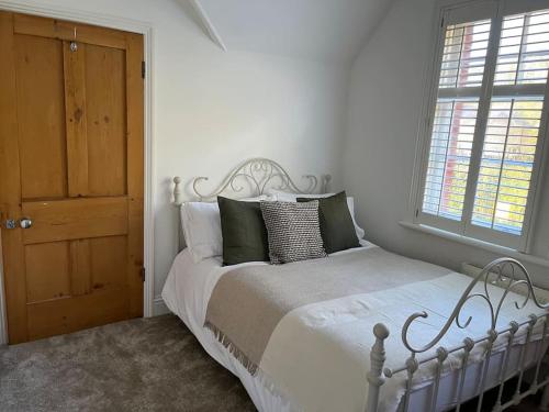 een witte slaapkamer met een bed en een raam bij Station House-Hinton Admiral in Christchurch