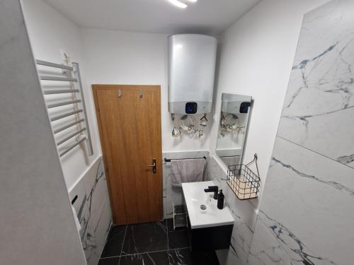 a bathroom with a sink and a wooden door at Apartman"Petra" in Krk