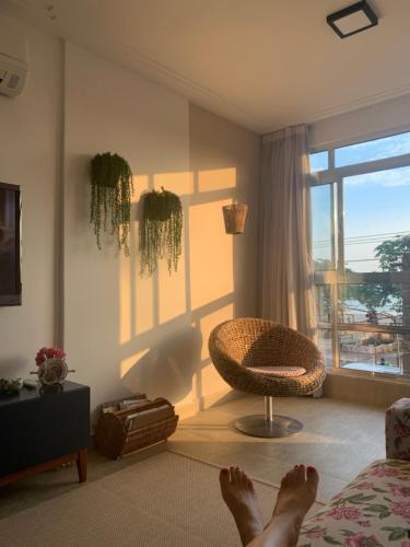 una persona acostada en una cama en una habitación con ventana en Apartamento frente Mar Santos en Santos