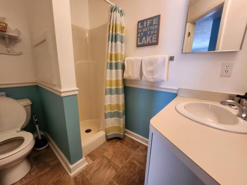 La salle de bains est pourvue de toilettes, d'un lavabo et d'une douche. dans l'établissement North Shore Inn TC 308, à Traverse City