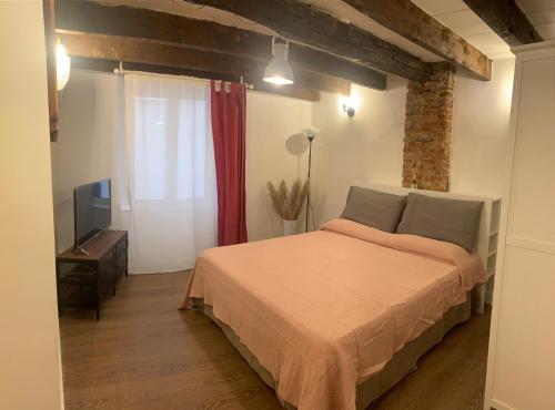 1 dormitorio con 1 cama y TV en CASA CIMELLA, un nido nel cuore del porto antico cod CITRA 010025-LT-2629, en Génova