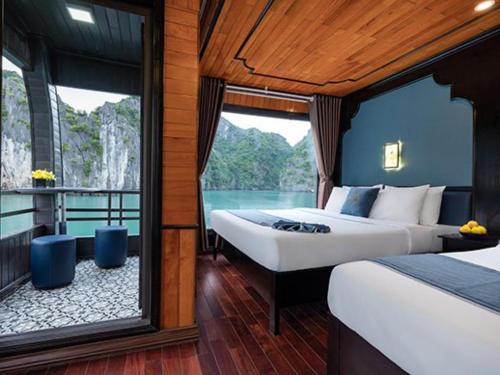 2 Betten in einem Zimmer mit Blick auf das Wasser in der Unterkunft The Boutique Cruise in Cát Bà