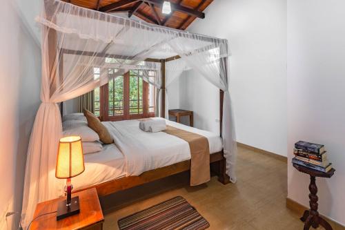 1 dormitorio con 1 cama con dosel en Villa Mount Melody, en Kandy