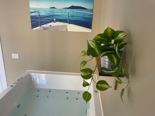 een badkamer met een bad met een plant bij Colombo 32 Affittacamere in La Spezia