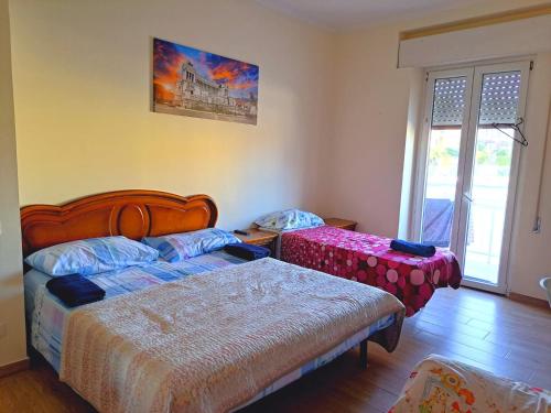 una camera con due letti e una finestra di Cozy Rooms Rome a Roma