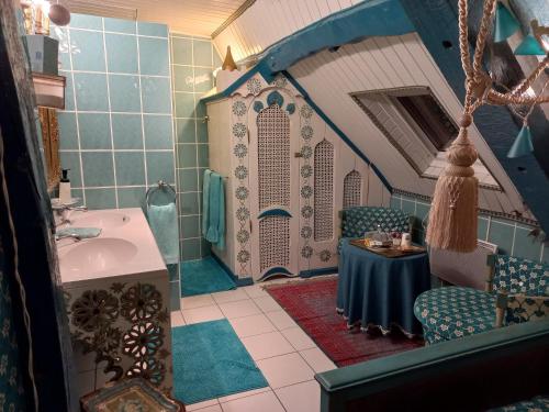 La salle de bains est pourvue d'un lavabo et d'une table. dans l'établissement Location meublé de tourisme La Rose des Fables, à Château-Thierry