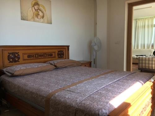 a bedroom with a bed with a wooden head board at The sea 700 mt. from the house Wi-Fi and parking in Spadafora