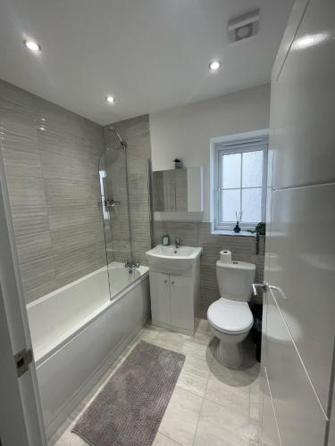 uma casa de banho com um WC, uma banheira e um lavatório. em The Rita House em Doncaster