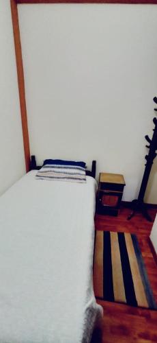 a bedroom with a white bed and a striped rug at The Little House ApartHotel in Uyuni