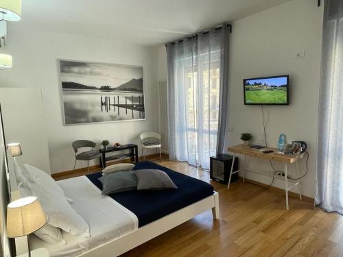 a bedroom with a bed and a desk and a window at Colombo 32 Affittacamere in La Spezia
