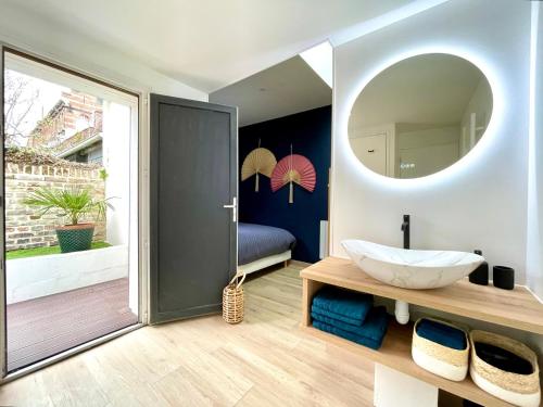 uma casa de banho com um lavatório e um espelho em Soleil Levant : calme et terrasse, proche gare em Amiens