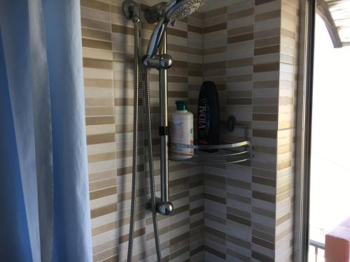 a shower in a bathroom with a tile wall at The sea 700 mt. from the house Wi-Fi and parking in Spadafora