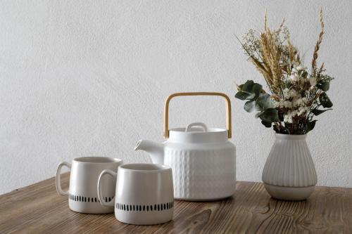 a table with three cups and a vase with flowers at FORET TOTEM - Hébergements nature et bien-être en pleine forêt in Persquen
