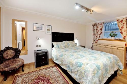 a bedroom with a bed and a chair and a window at Grand Mansion 9 Beds Sleeps 17 Parking - Groups in Aberdeen