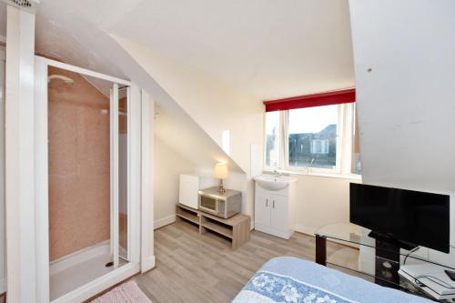a living room with a bed and a television at Grand Mansion 9 Beds Sleeps 17 Parking - Groups in Aberdeen