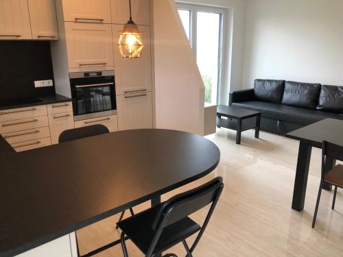 a kitchen and living room with a black table and chairs at Résidence du Golf Eselborn in Eselborn