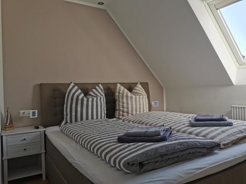 een bed met twee kussens in een kamer bij Moderne Wohnung mit Privatpool in Büsum