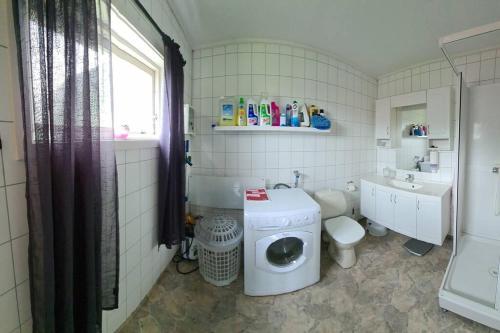 a bathroom with a washing machine and a toilet at Cozy house - Strønstad @the start of Lofoten in Strønstad