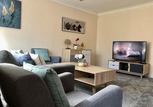 a living room with two couches and a tv at Maidstone-Penenden House in Maidstone