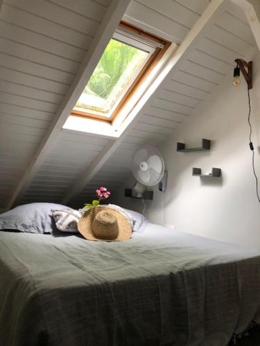 um quarto com uma cama com um chapéu em Bungalow Le Jasmin de Nuit em Les Abymes