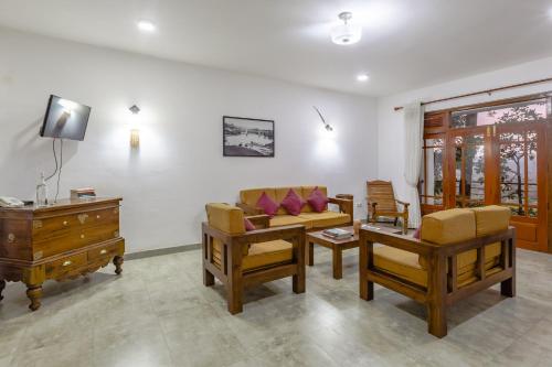 a living room with a couch and chairs and a dresser at Villa Mount Melody in Kandy