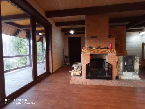 a living room with a fireplace in a house at Велика Дзен Хата in Dzembronia