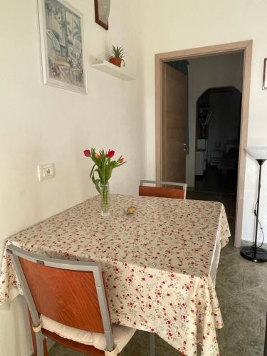 a dining room table with a vase of flowers on it at Apartments Šterna in Grožnjan