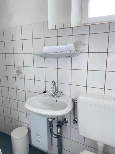 Baño blanco con lavabo y aseo en Moderne Monteurwohnung in Mönchengladbach Rheydt, en Mönchengladbach