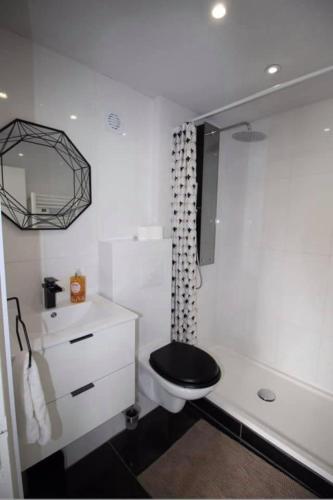 uma casa de banho com WC e assento preto em Cocon de douceur 
