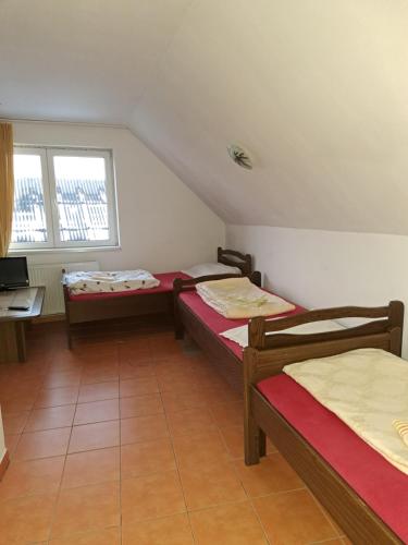een kamer met 3 bedden, een bureau en een raam bij La Bibicu in Agnita