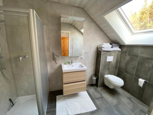 a bathroom with a sink and a shower and a toilet at Holiday Deluxe Apartment in Travers