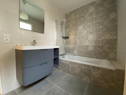 a bathroom with a sink and a bath tub and a mirror at Appartement CLUSES CENTRE in Cluses