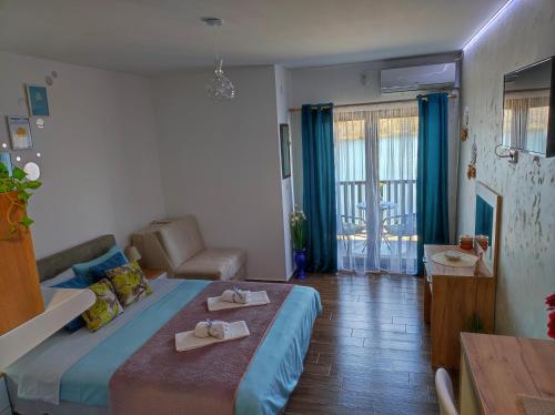a bedroom with a bed and a couch and a table at Adonis in Ostrovo