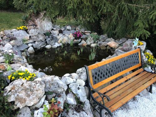 a bench sitting in front of a pond with flowers at Apartments Šterna in Grožnjan