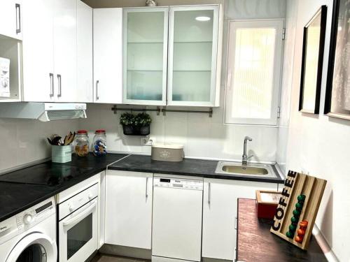 a white kitchen with a sink and a dishwasher at Cómodo y acogedor apartamento in Madrid