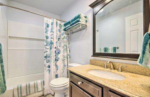 a bathroom with a sink and a toilet and a mirror at Osage Beach Resort Condo with Community Pool! in Osage Beach